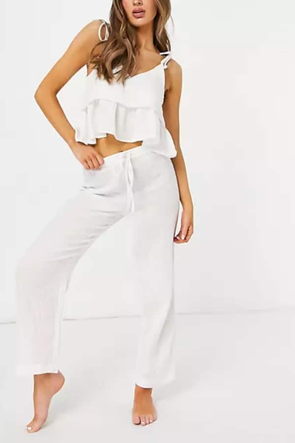 Woman wearing white two-piece summer beach outfit.