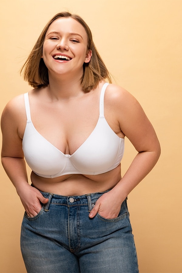 Smiling woman wearing bra and jeans