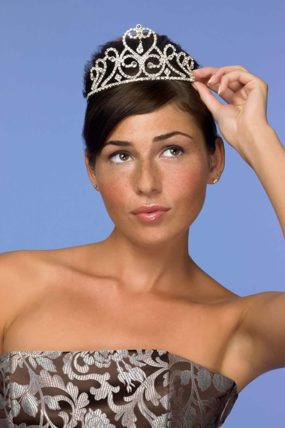 Close up of woman wearing tiara and formal dress.