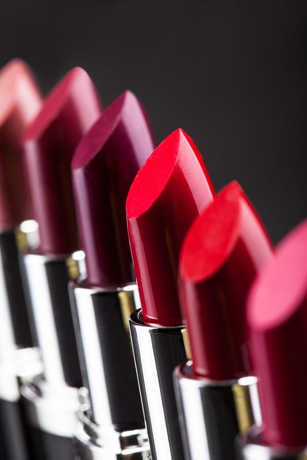 Collection of lipsticks in different tones of red and purple.