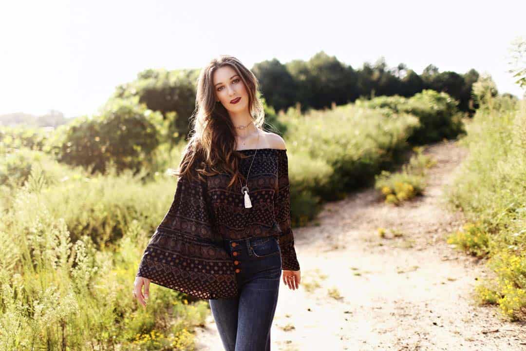 Woman wearing off-shoulder, wide sleeve blouse