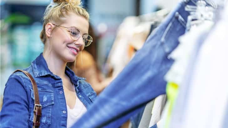 Woman smiles shopping in thrift store.