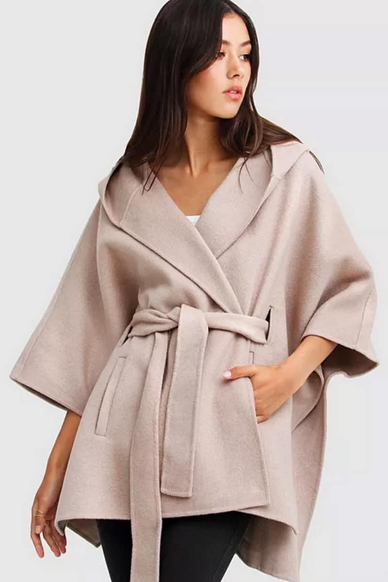 Woman wears belted cape.