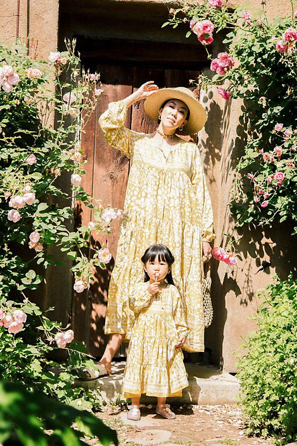 Mother and daughter wearing matching yellow patterned dresses 
