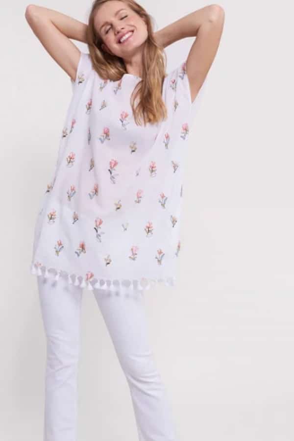 Woman wearing lightweight white tunic with flower print 