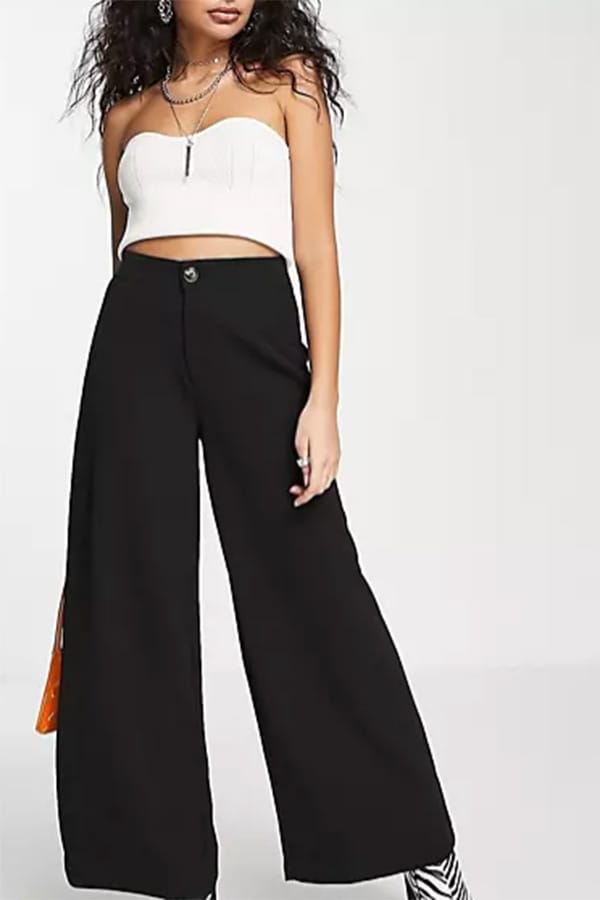 Model wears wide-legged petite jeans by Noisy May.