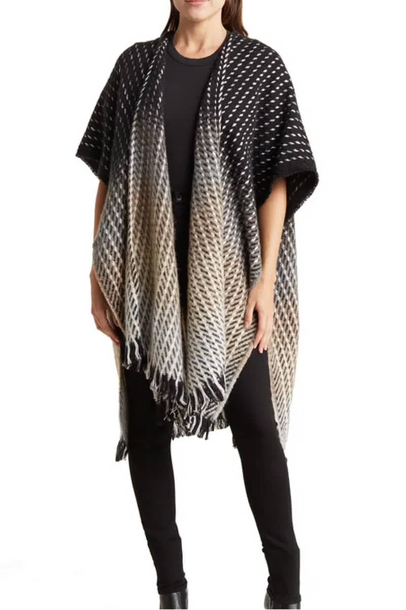 Model demonstrates how to wear a cape with skinny pants. 