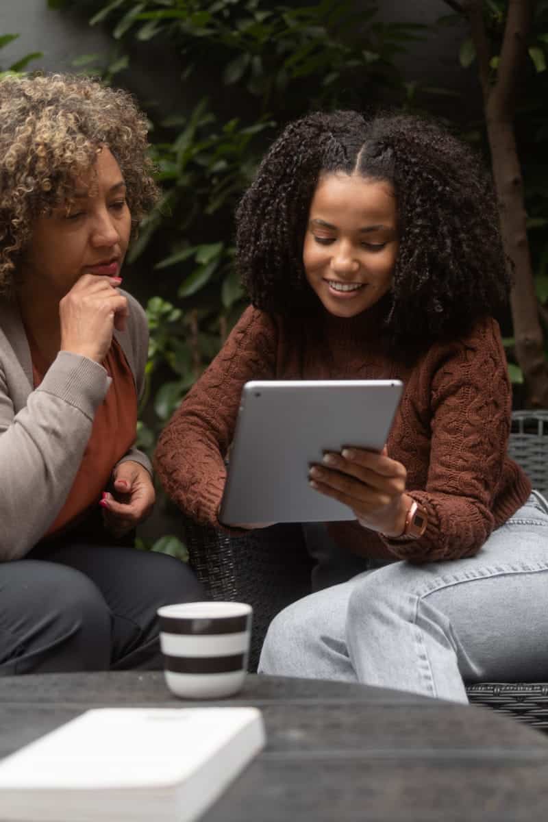 Two women shop midrange fashion online.