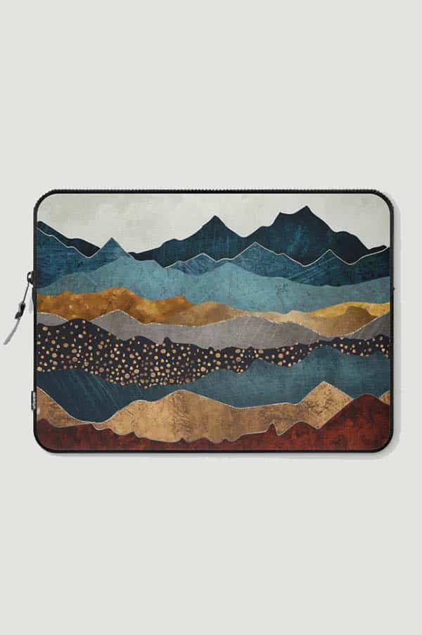 Laptop sleeve with landscape in muted blues and tans.