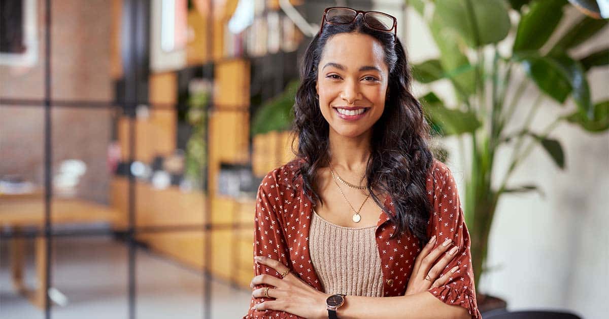 Smiling woman looking at camera in front of clothing store.