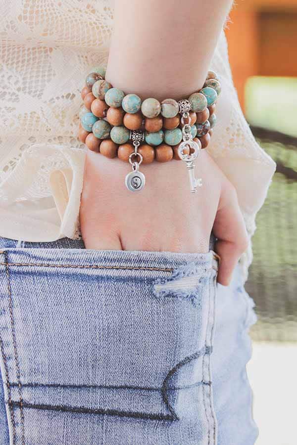 Close up of bracelet stack on woman's wrist.