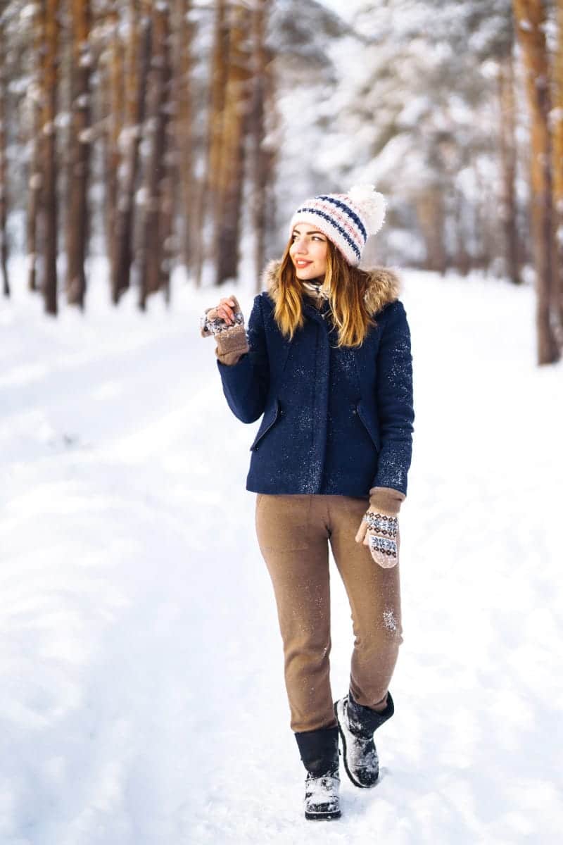 Woman wearing winter jacket outside in the snow.