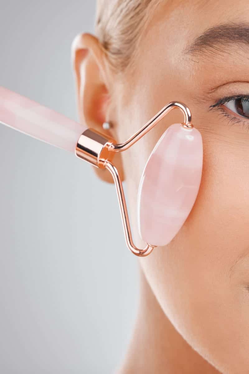 Close up of woman using beauty roller.