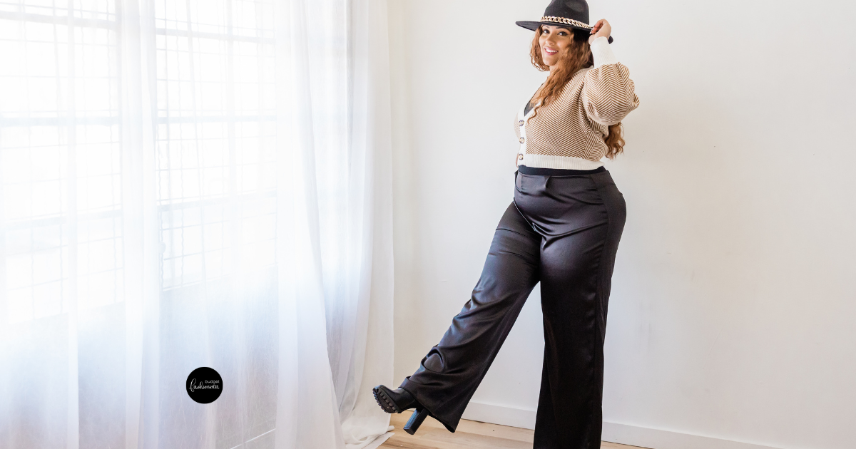 Woman in hat, sweater, and black wide-leg pants.