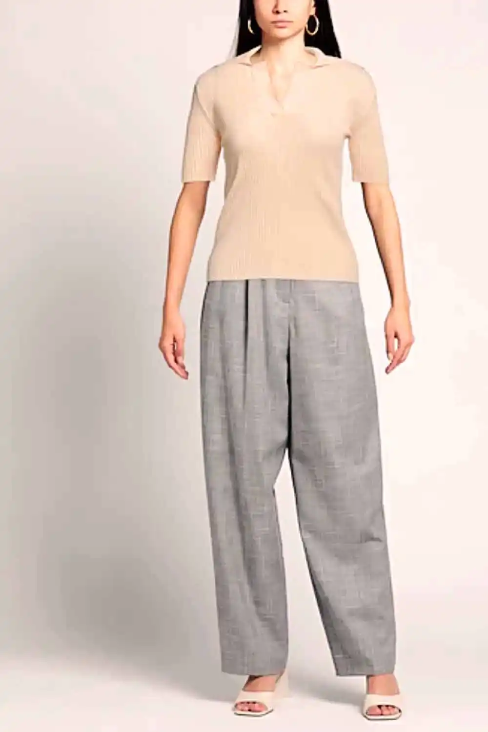 Model wearing short-sleeved, collared sweater with baggy pants.